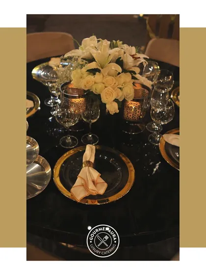 A close-up of a perfectly set table with gold-rimmed plates and floral centerpieces.