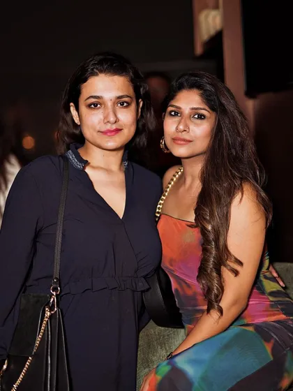 Two friends posing for a photo, enjoying their night out.