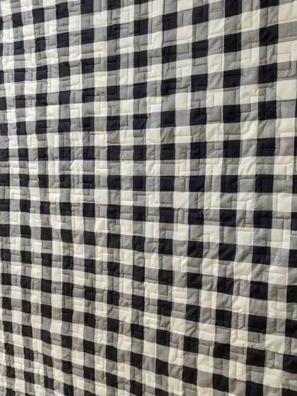 The back of a quilt, featuring a classic black and white gingham pattern.