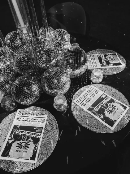 Disco balls and custom "The Fegan Times" newspaper programs set the tone for a disco-themed party. The limit for sparkle does not exist.
