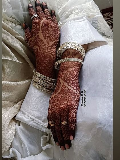 Another shot of the stunning bridal stain. The deep color of the henna looks so rich against the white fabric and silver bangles.