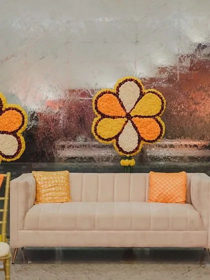 A seating area featuring large, flower-shaped installations made entirely of marigolds. This creative use of traditional flowers added a unique and artistic touch to the spiritual event.