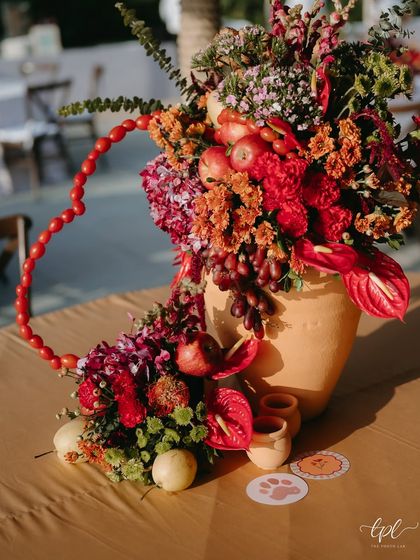 A centerpiece from the tropical event, with a heart-shaped garland of cherry tomatoes and custom coasters with the couple's pets.