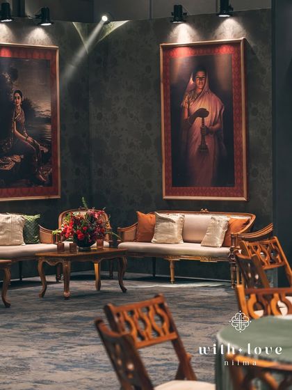 A wide shot of the lounge area, where guests can relax on classic sofas surrounded by art. The lighting is kept low and warm to enhance the moody, romantic atmosphere.