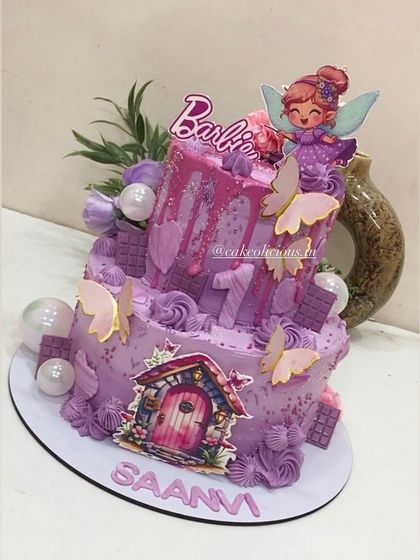A monochromatic lavender-shaded cake for a first birthday. This two-tier design combines a Barbie fairy theme with butterflies and a magical fairy door, all in beautiful shades of purple.