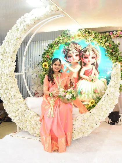 The mom-to-be poses against a beautiful crescent moon backdrop, showcasing her full floral jewellery set and basket.