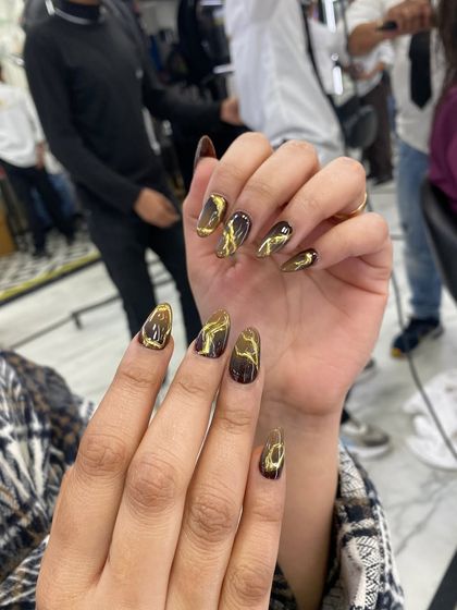 A dramatic and trendy design featuring a black base with a gold liquid marble or "cat-eye" effect, creating a bold and luxurious look.