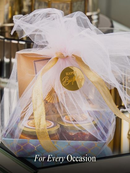 Our hampers are perfect for every occasion, from birthdays to anniversaries. This beautifully wrapped gift box includes a 'Happy Birthday' sticker, showing how we tailor each hamper to your celebration.