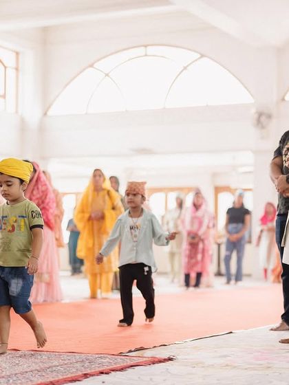 Children wander and play during the Anand Karaj ceremony. These candid moments of the youngest guests add a layer of authenticity and charm to the wedding album.