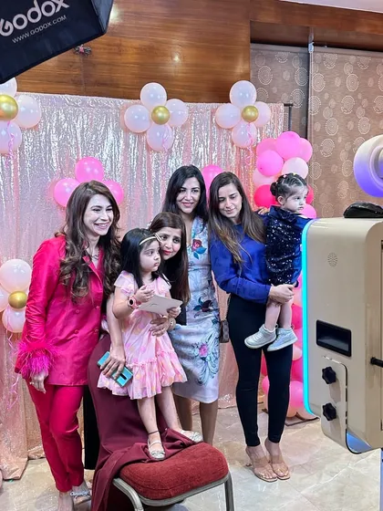 A group of friends and family celebrating a 5th birthday party. The photo booth is always a hit with guests of all ages, capturing candid moments of fun.