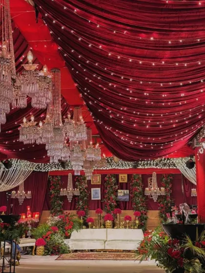 Go big or go home. For this reception, we used rich red velvet drapes across the entire ceiling, dozens of crystal chandeliers, and dramatic floral arrangements to create a warm and luxurious atmosphere. This is our signature red romantic theme.