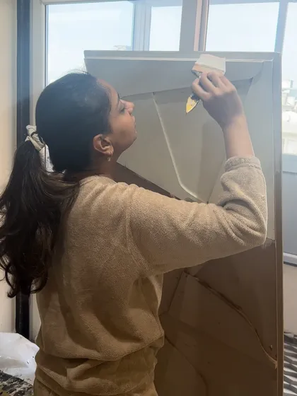 Carefully painting the edges of a custom MDF board piece. Finishing the sides properly is a crucial step that gives the artwork a polished, professional look.