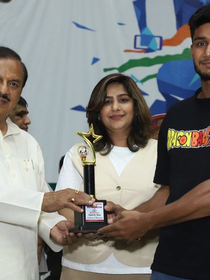 An athlete is presented with a trophy by Dr. Mahesh Sharma during the National Sports Day event. Our venue is a place of recognition and celebration for sporting excellence.