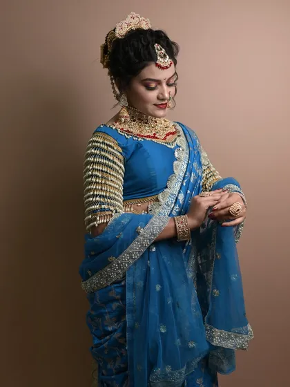 A graceful pose showing the full effect of the student's work, including the traditional hairstyle and saree draping.