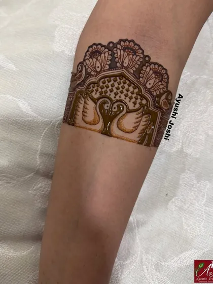 A close-up of the armband from the engagement mehendi, featuring two swans in a royal arch.