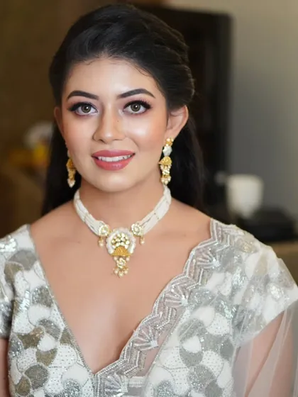 A full-length view of this client's elegant look. The makeup provides a polished finish that ties her entire silver and white ensemble together perfectly.
