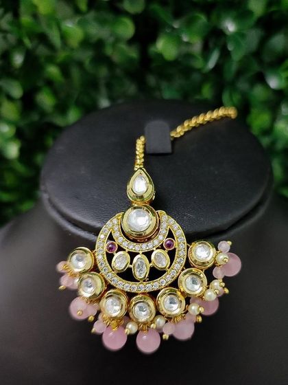 A beautiful kundan maang tikka with soft pink bead drops, perfect for a pastel-themed wedding.