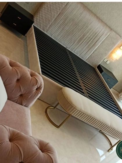 A luxurious bedroom setting featuring a bed with a grand, tufted headboard and a matching pink tufted settee at its foot. The design exudes opulence and comfort, creating a truly lavish retreat.