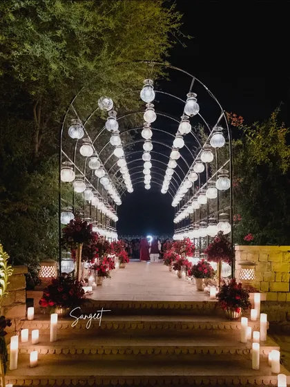 A tunnel of lights created a grand and dramatic entrance for the sangeet. Lined with candles and red floral arrangements, this walkway was designed to build anticipation and make guests feel like they were stepping into another world.