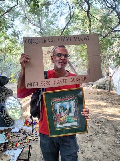 A happy shopper holds up his new piece of art, found at our thrift stall. Our 'Purana Baksa' is more than just a sale, it's a way to promote a circular economy and give beautiful objects a second life.