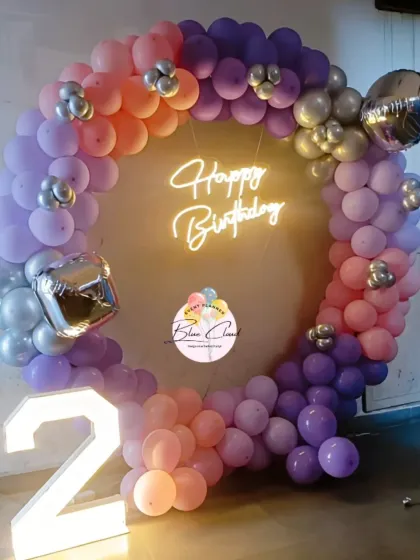 A beautiful sunset-colored balloon ring in shades of orange, purple, and pink for a second birthday.