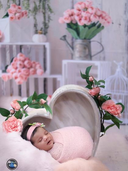 A wider view of the pink floral heart setup, showing the rustic white crates and watering can props that add to the shabby-chic aesthetic.