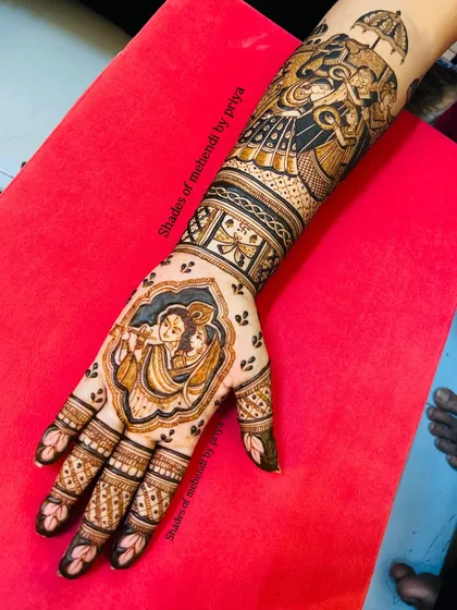 A full view of the hand and arm, showing how the Radha Krishna portrait on the palm connects seamlessly with the royal procession design on the arm.
