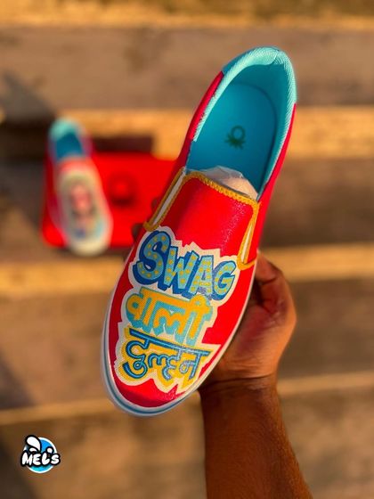A hand-held shot of the "Swag Wali Dulhan" custom bridal sneaker, showing the fun typography and bright colors.