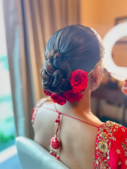 A side view of the red rose bun, showing the intricate braiding and the beautiful placement of the flowers.