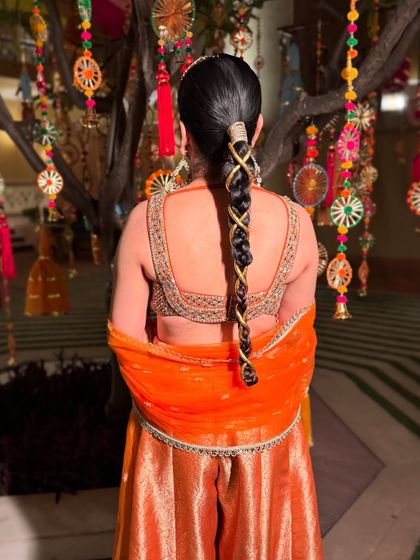 A close-up of this unique and modern braid. The criss-cross pattern with a gold thread is a creative way to elevate a simple braid for a Sufi night or Mehendi.