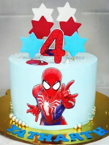 A simple and clean Spiderman cake for a 4th birthday. This fresh pineapple cake features the superhero against a light blue background with star decorations.