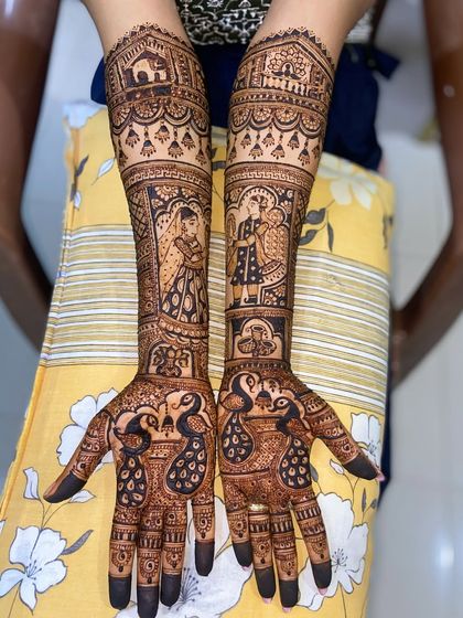 A full bridal design featuring portraits of a bride and groom, along with peacocks on the palms. The arms depict a wedding procession with a doli.