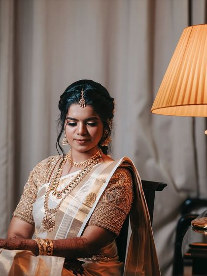 A seated portrait of the bride, looking peaceful and radiant. The soft lighting and her calm demeanor make for a beautiful and classic bridal photo.