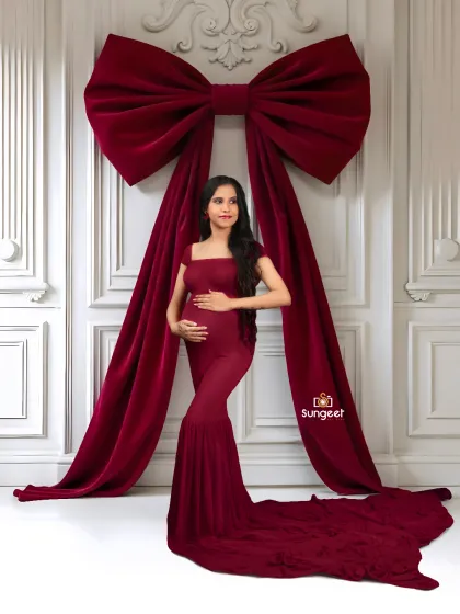 A fun and creative concept, presenting the baby bump as the ultimate gift. The giant red bow and matching gown make for a bold and memorable holiday-themed announcement.