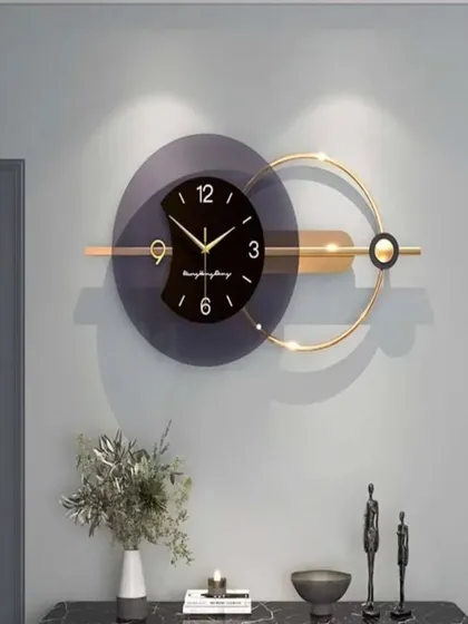 A contemporary design featuring a dark, semi-transparent disc and a golden ring. This imported metal wall clock plays with geometry and balance, making it an ideal statement piece for a modern living or dining room.
