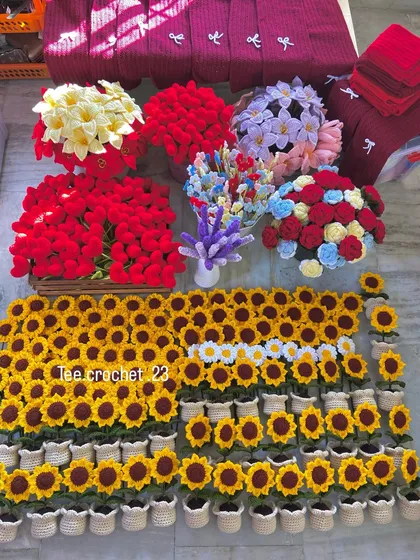 A huge wholesale order laid out, featuring potted sunflowers and large bunches of colorful flower stems.