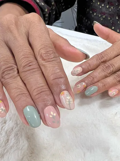 Simplicity at its best. This client chose a mix of pastel pink and green gel polish with delicate, hand-painted white floral accents.