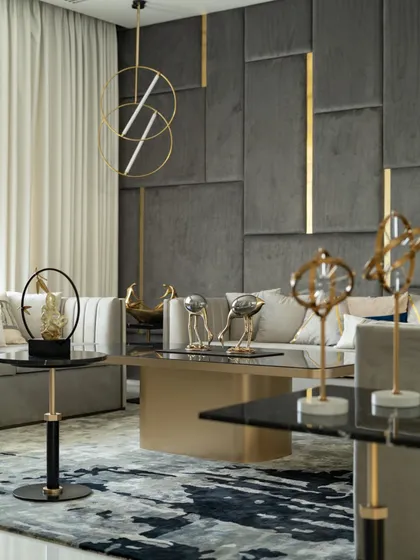 A formal seating area combines a plush grey sofa with gold and brass accents in the lighting and decor, creating an atmosphere of sophisticated luxury.