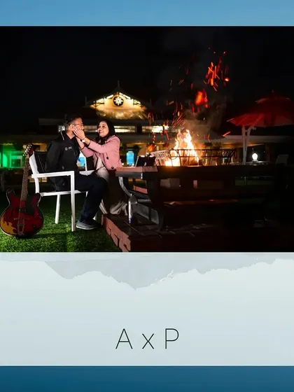 Another beautiful bonfire scene with Akash and Priya. The guitar adds a personal touch, suggesting a story of shared songs and cozy nights together.