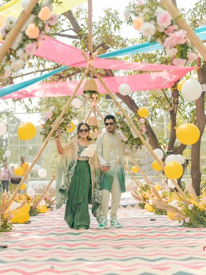 The couple's grand entrance to their haldi ceremony. The colorful decor and their cool sunglasses set a fun, festive mood.