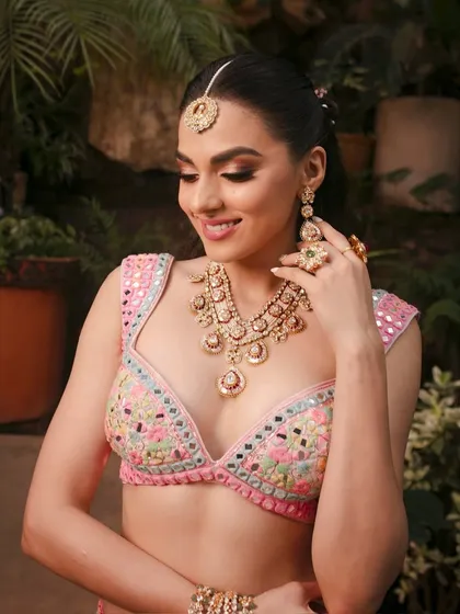 A close-up of the intricate mirror-work blouse and the soft, glowing makeup that complements it perfectly.