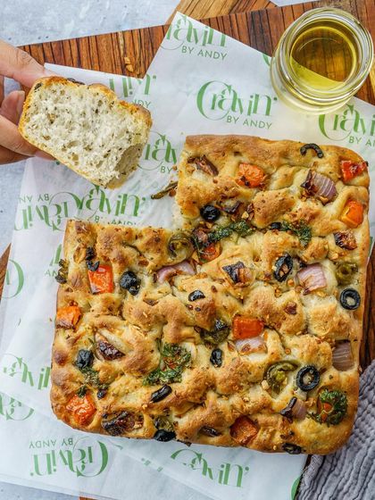 A colorful vegetable focaccia, shot from above. This image highlights the fresh toppings and the soft, airy texture of the bread. It’s a beautiful and appetizing shot for a bakery.