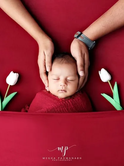 We believe in capturing the whole family's love. This tender moment shows a newborn's head cradled safely in their parents' hands, a simple yet powerful portrait of connection that is always part of our sessions.