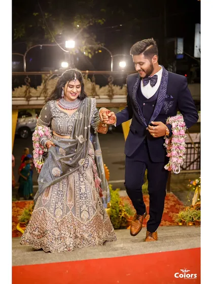 The couple makes their entrance at the reception, with the groom leading his bride down the red carpet.