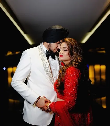 A quiet, romantic moment captured amidst the celebration. The dark background makes the couple the sole focus, highlighting their embrace.