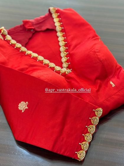 A classic red blouse with Kasu or coin embroidery along the neckline and sleeves.