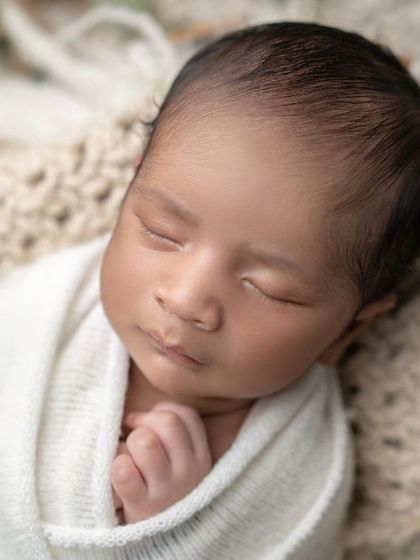 Deep in dreamland. This close-up captures the serene expression of a sleeping newborn, a moment of pure peace.