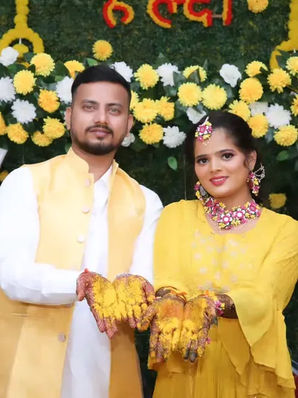 The couple holding out their hands full of haldi, a classic and joyful shot from the ceremony.