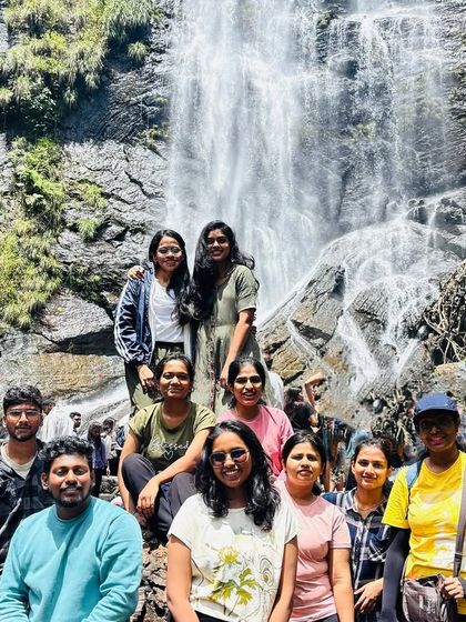A group photo at the base of a waterfall during our Explore Chikmagalur trip, a perfect way to cool down.