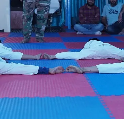 Four students demonstrate perfect floor splits, a result of our consistent and structured flexibility training. This level of flexibility is key to executing high kicks and advanced techniques.